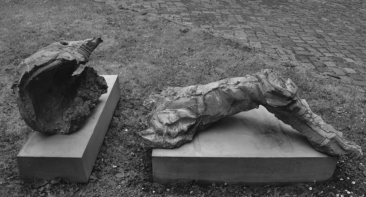 drei(3(III)): two cast concrete pieces on low concrete plinths, outdoors on grass