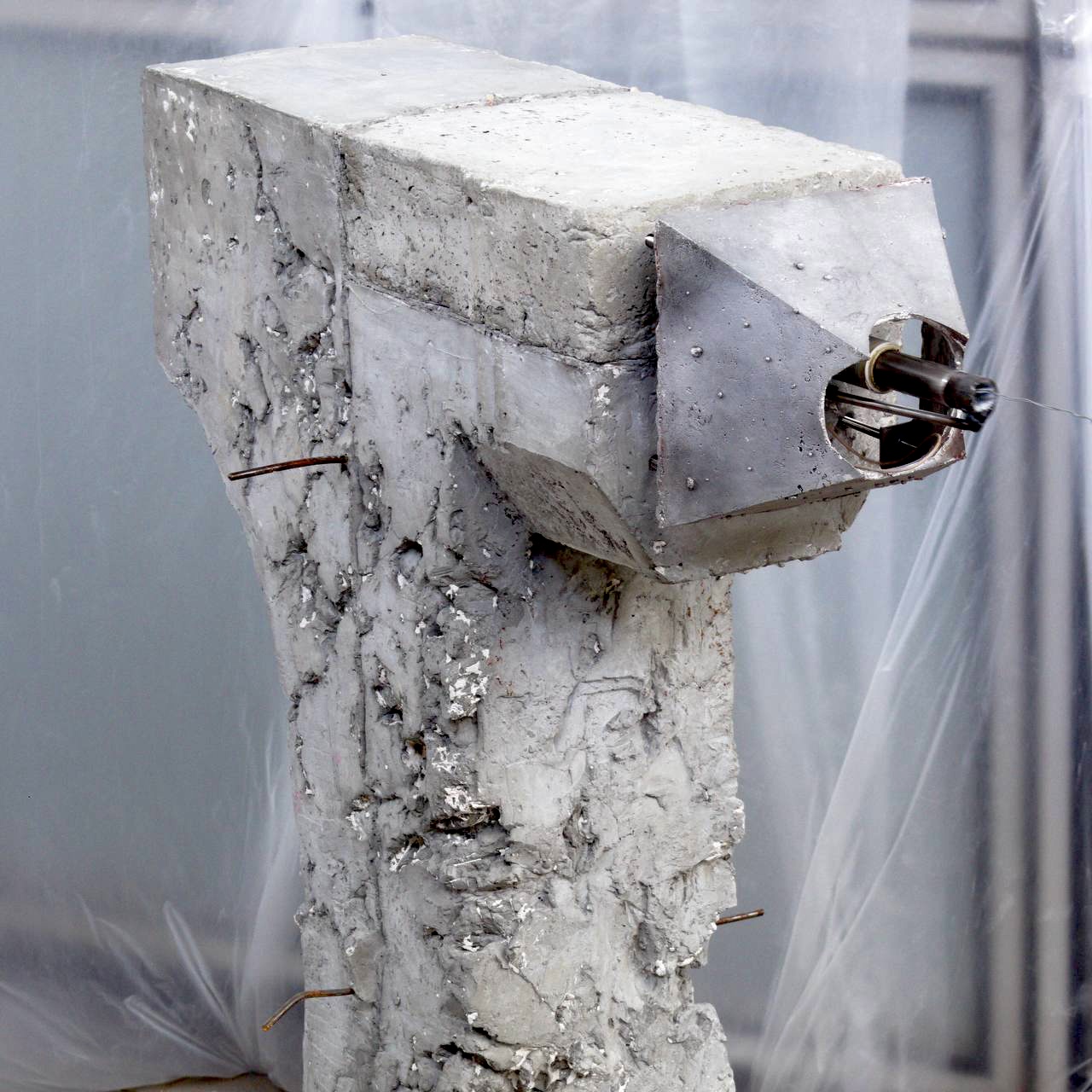 Visualizer: a rough concrete column with a faceted head and the linear motor reaching out of it